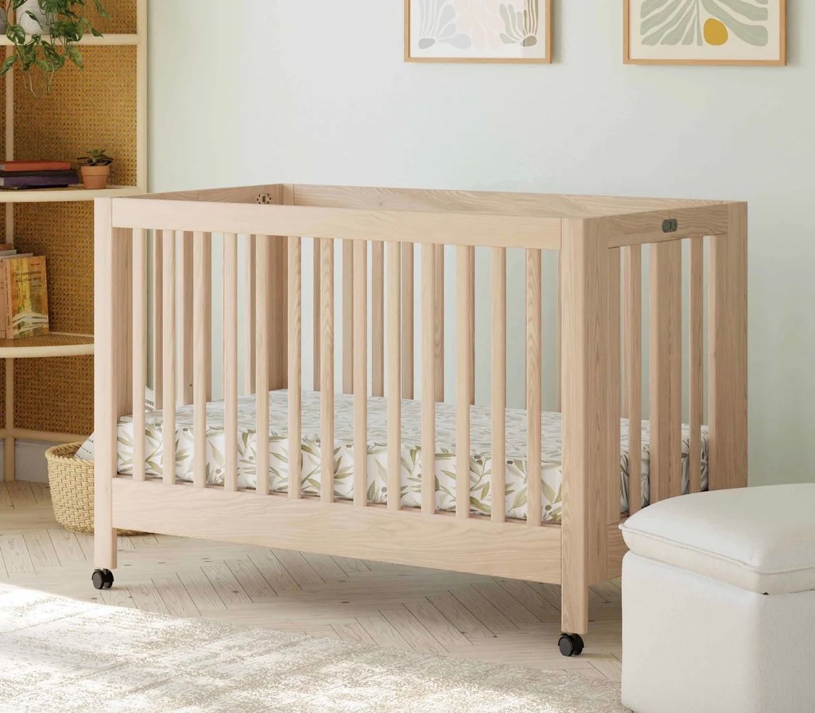 Babyletto Maki natural-wood full-size crib made up in a bright nursery